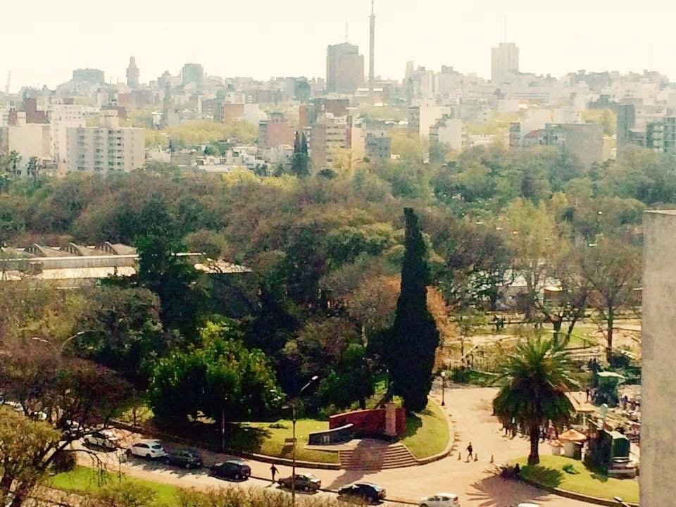 Vista de Montevideo desde la altura, con el Parque Rodó en primer plano y los edificios hacia el horizonte.